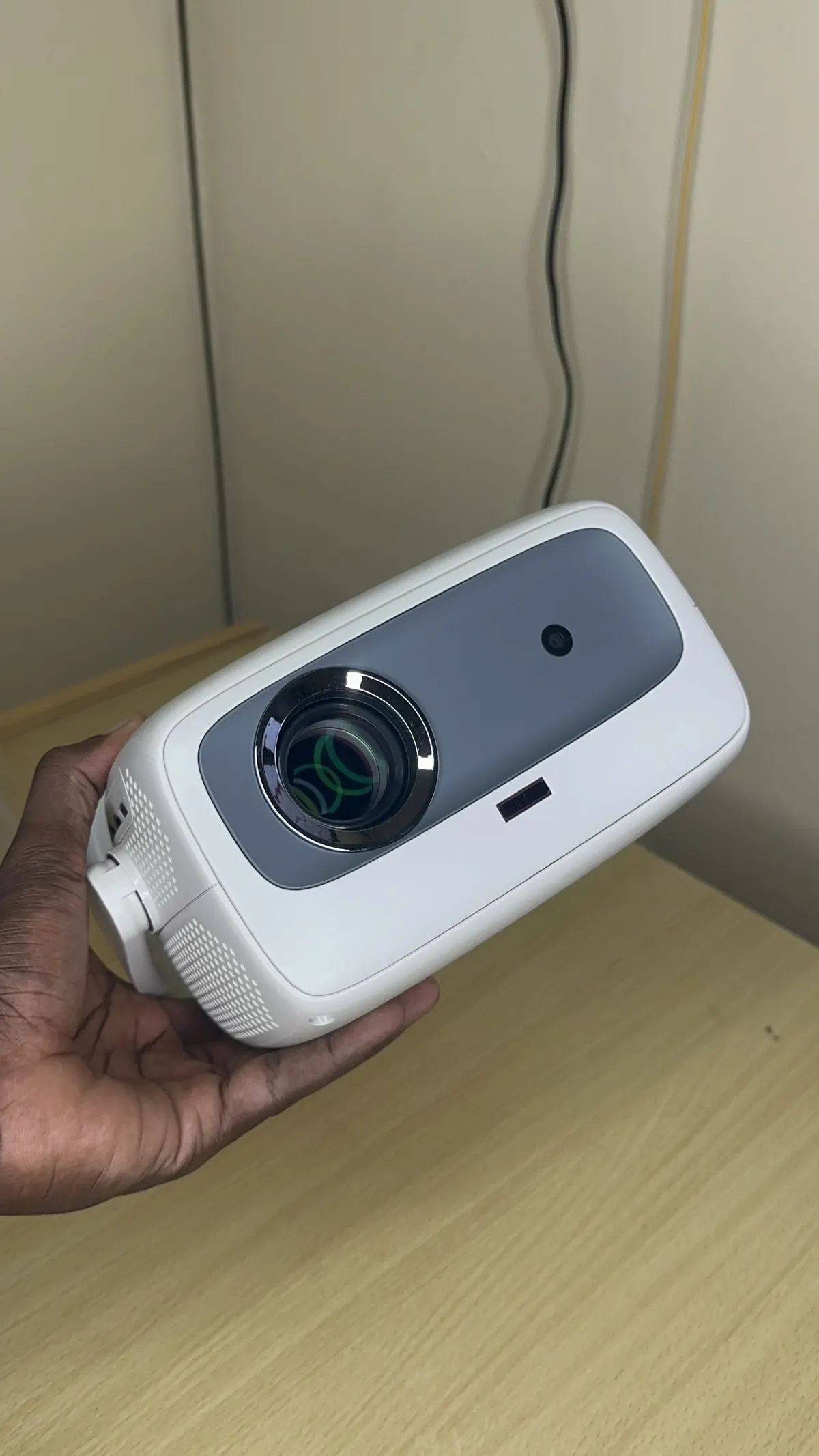 Photo réelle : le projecteur tenu en main, compact